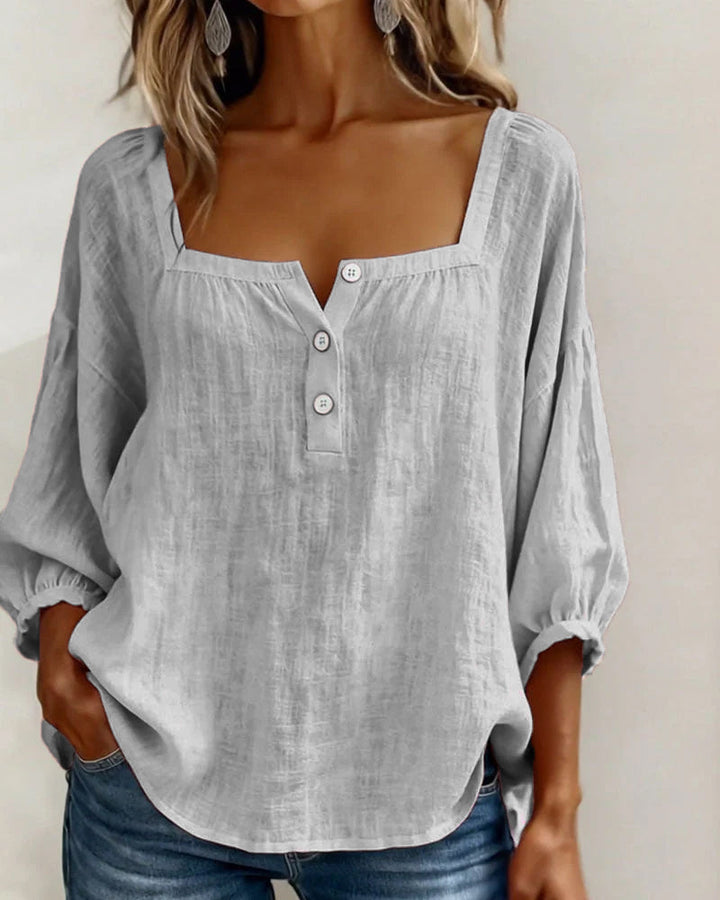 Blusa sencilla con escote cuadrado y mangas largas.