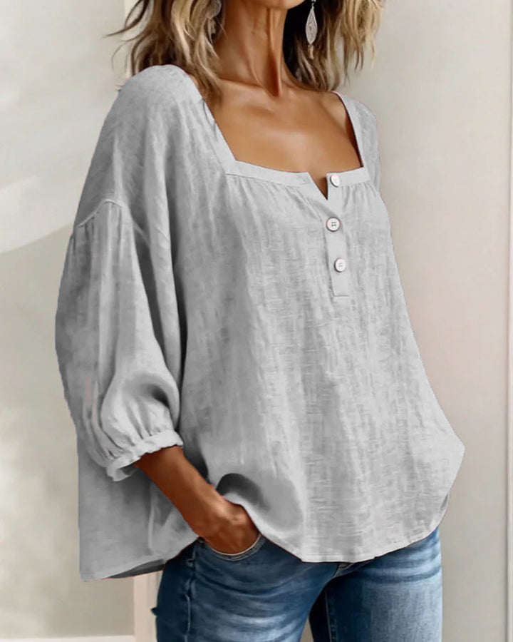 Blusa sencilla con escote cuadrado y mangas largas.